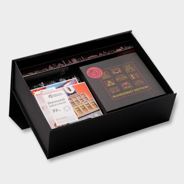 Große Geschenkbox mit ausgewählten Produkten von Pott au Chocolat: Eine Pralinenbox mit Ruhrgebiet-Pralinen, eine Pralinenstange mit 10 Pralinen und zwei Tafeln Schokolade in einer Verpackung im Ruhrgebiet-Design