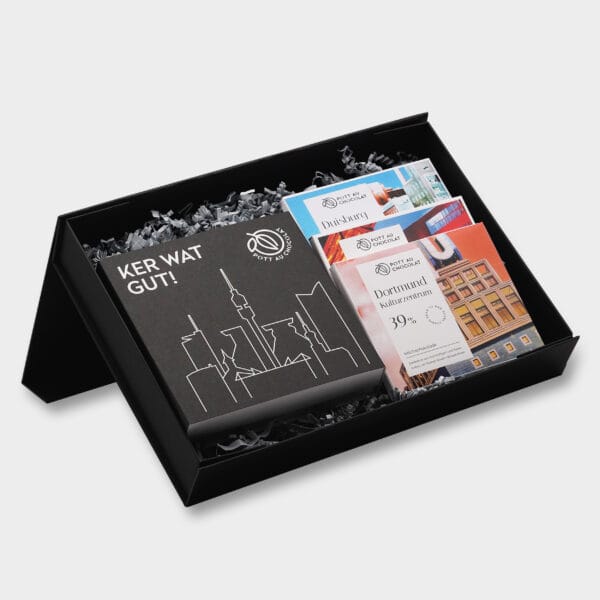 Geschenkbox mit verschiedenen Produkten von Pott au Chocolat: Eine Pralinenbox und drei verschiedene Tafeln Schokolade in Verpackung mit Ruhrgebiet-Design