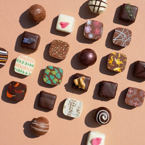 Verschiedene Sorten Pralinen von Pott au Chocolat auf einem Beige-Braunen Hintergrund