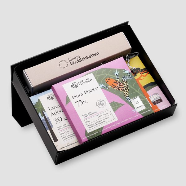 Schwarze Geschenkbox mit einer Pralinen-Stange für 6 Pralinen in beige und schwarz und drei puren Schokoladen-Tafeln mit buntem Design.