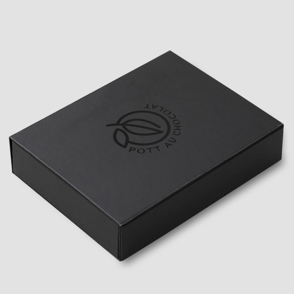 Geschlossene Geschenk Box - komplett schwarz, das Logo von Pott au Chocolat in der Mitte sichtbar. Auch in schwarz mit leichtem Glanz und geprägt.