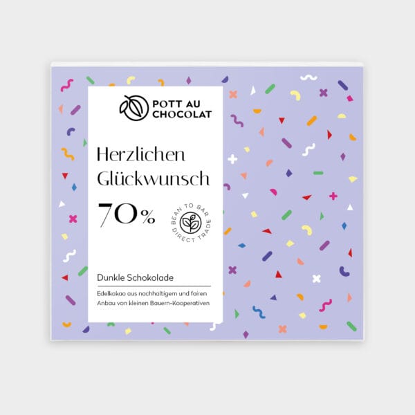 Die Verpackung einer Schokoladentafel mit der Aufschrift 'Herzlichen Glückwunsch' ist in Lila gehalten, mit bunten Luftschlangen im Hintergrund. Kakaoanteil 70 Prozent