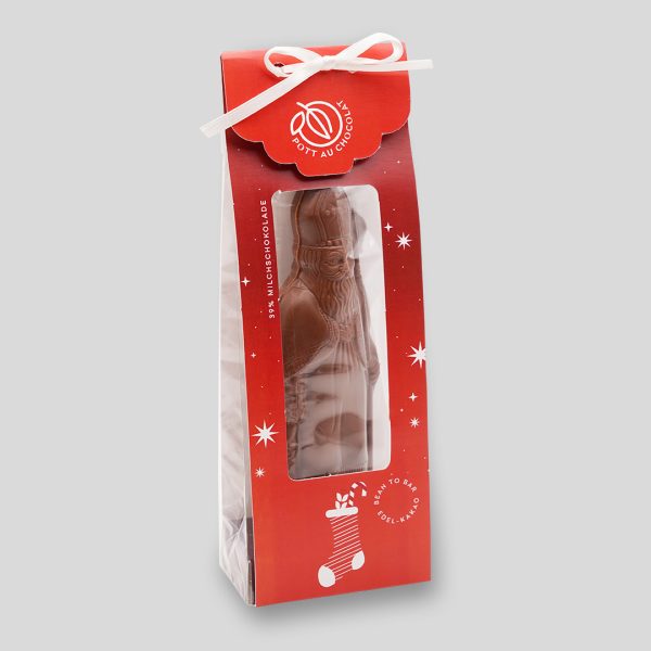 Schoko Nikolaus in Milchschokolade in roter Verpackung mit weißer Schleife und mit Sichtfenster.