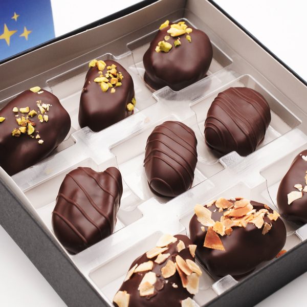 Geöffnete Box mit 9 verschieden dekorierten Datteln in einem Blister.