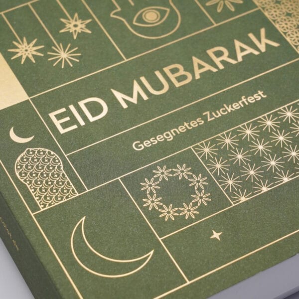 Detail einer Pralinen Schachtel mit dem Aufdruck 'Eid Mubarak - Gesegnetes Zuckerfest' in Gold. Zusätzlich feine Illustrationen, gold geprägt
