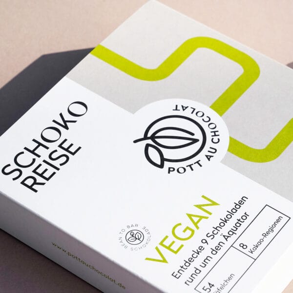Verpackung der Schoko Reise in vegan. Weiße Schachtel mit bedruckter Banderole in den Farben weiß, grau, schwarz und hellgrün.