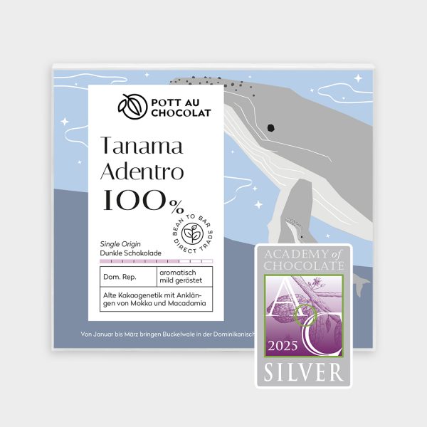 Verpackung der Tafel Tanama Adentro 100% mit einem Motiv in hellen Blau- und Grautönen mit einem Wal im Meer. Abgebildet ist außerdem eine Auszeichnung von der Academy of Chocolate 2025, Silber .
