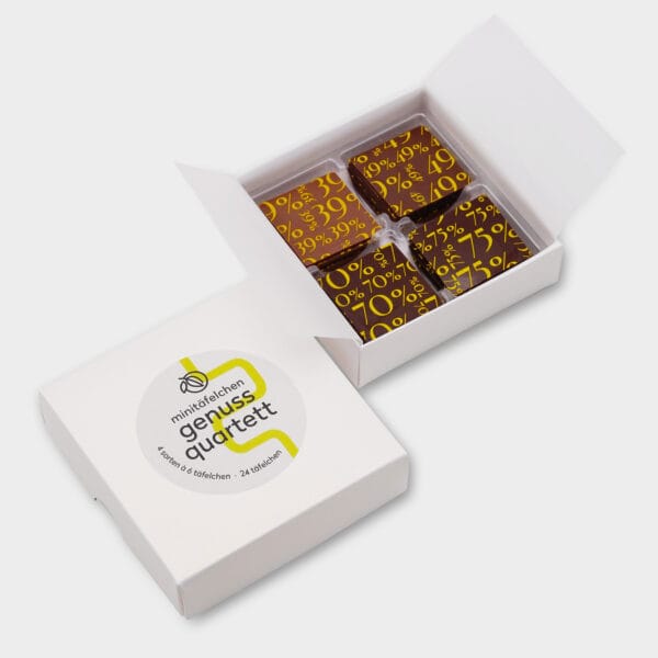 Genuss-Quartett mit 4 verschiedenen Täfelchen Schokolade in Verpackung. Die Box ist geöffnet, sodass die Täfelchen sichtbar sind. Weiße Verpackung mit hellgrauem Sticker und hellgrünen Akzenten