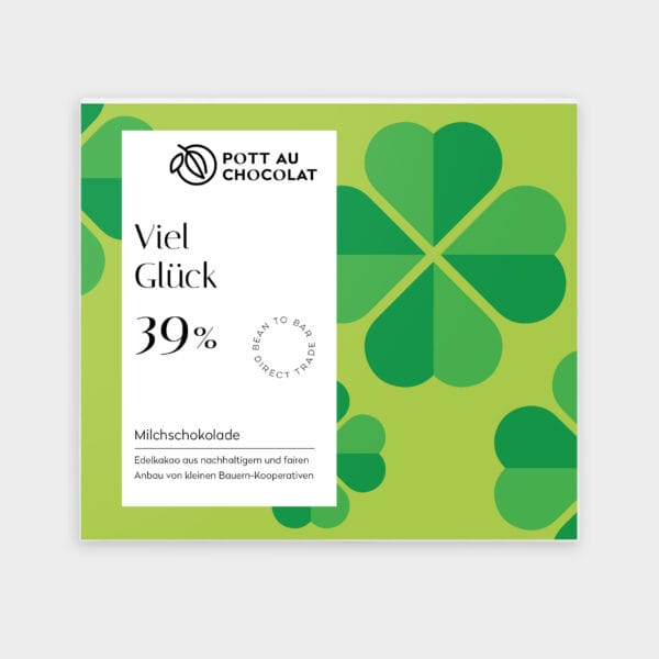 Verpackung unserer Motto Milchschokolade "Viel Glück". Hellgrüner Hintergrund mit grafisch dargestellten grünen vier blätterigen Kleeblättern darauf ein weißes Rechteck mit der Bezeichnung und unserem Logo