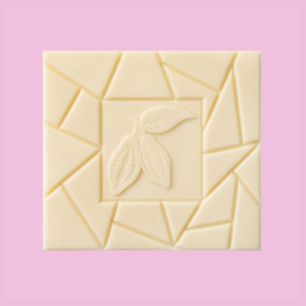 Vorderseite unserer weissen Schokoladentafel vor pinkem Hintergrund. In der Mitte ein Quadrat mit der Kontur von zwei Kakaobohnen und einem Kakobaumblatt, drum herum unregelmäßig angeordnete Buchkanten