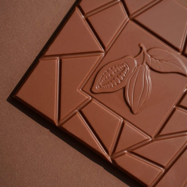 Milchschokoladen Tafel von Pott au Chocolat mit Muster und Kakaobohne auf braunem Hintergrund