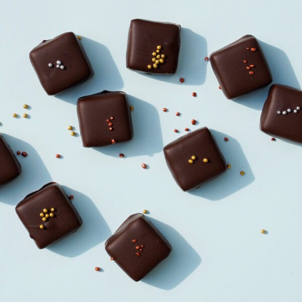 Verschiedene Sorten Whisky-Pralinen von Pott au Chocolat von oben auf hellblauem Untergrund fotografiert