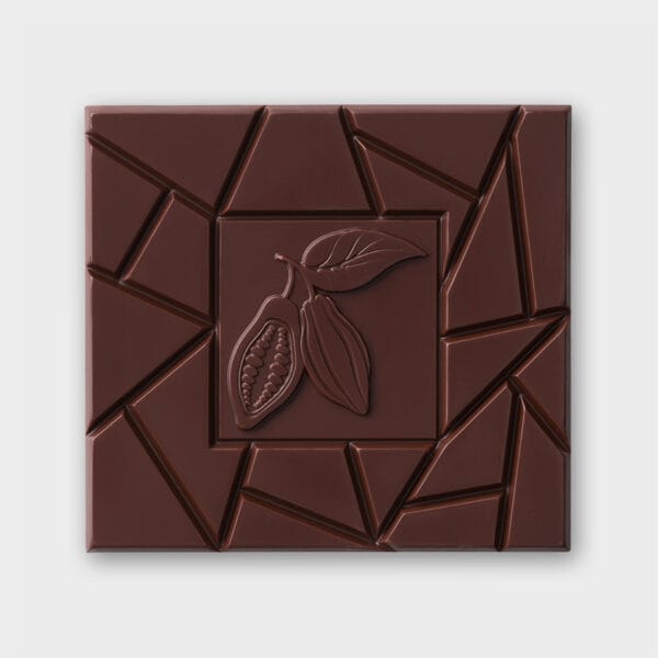Vorderseite unserer dunklen Schokoladentafel vor grauem Hintergrund. In der Mitte ein Quadrat mit der Kontur von zwei Kakaobohnen und einem Kakobaumblatt, drum herum unregelmäßig angeordnete Buchkanten