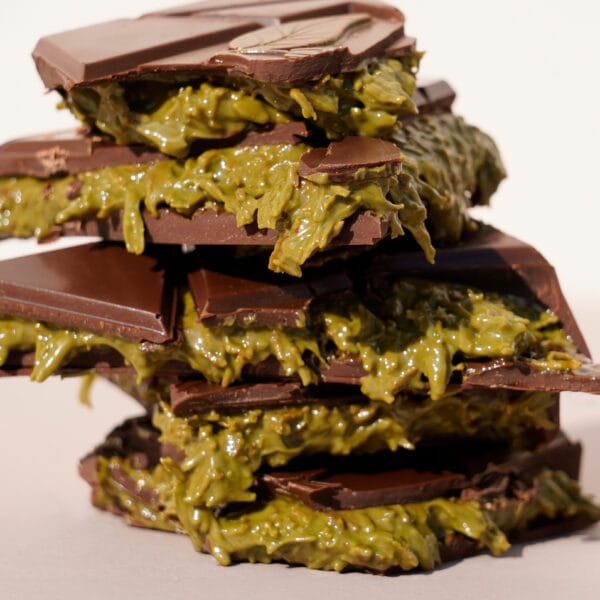 Übereinander getürmte aufgebrochene Dubai Style Schokolade aus denen die Füllung aus grüner Pistazienpaste mit den knusprigen Kadayif (Engelshaar) Fäden quellen