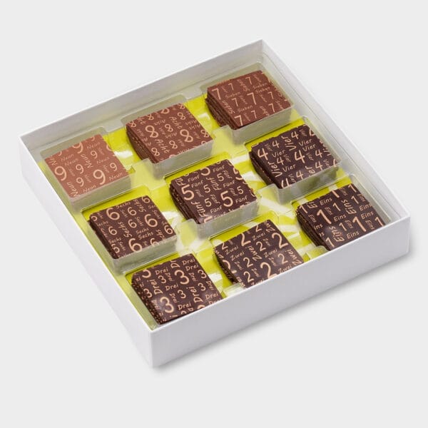 offene weisse Box mit 9 kleinen Probiertafeln mit der Aufschrift von 1 bis 9 auf hellgrünem Einleger.